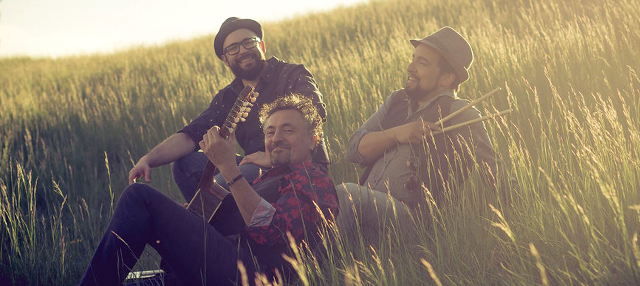 three of the four artists of the band in the grass